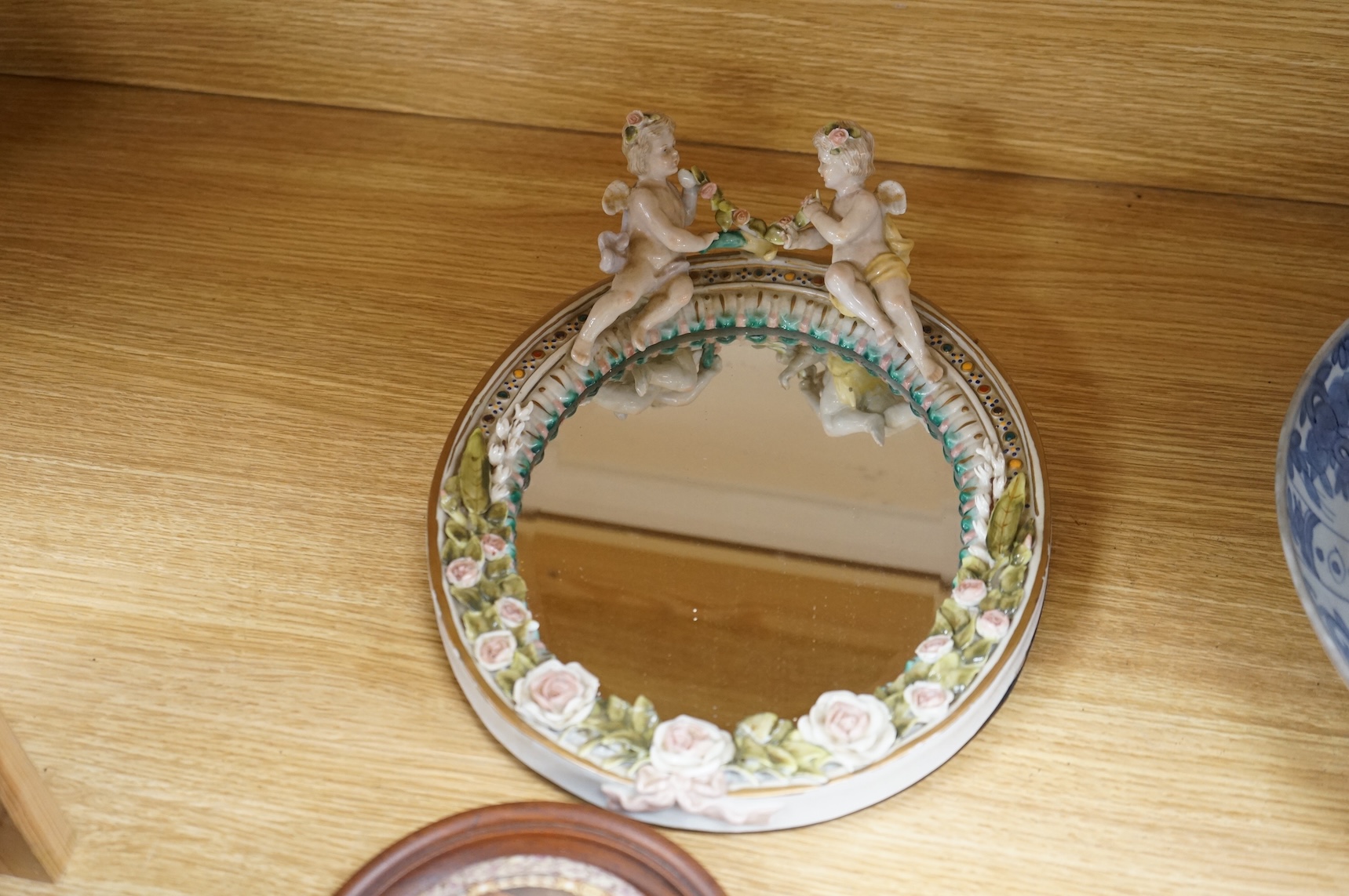 A Duke of Wellington pot lid, another Prattware pot lid and a German floral encrusted porcelain mirror, largest 33cm high